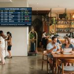 menampilkan suasana lobi hotel modern yang menyatu dengan area kafe