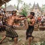 Dua pria melakukan tradisi Perang Pandan Mekare-kare di Tenganan Bali disaksikan warga