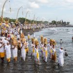 Umat Hindu mengenakan pakaian adat putih melakukan prosesi Melasti di pantai menjelang Hari Raya Nyepi