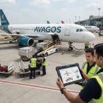 Petugas bandara memeriksa fitur weight and balance dan load control otomatis di AVAGOS menggunakan tablet.