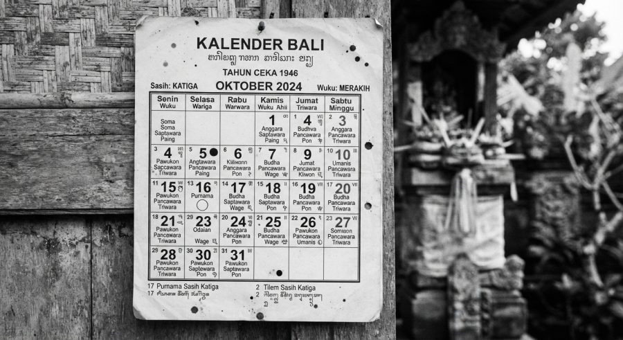 Kalender Bali hitam putih tradisional dengan aksara Bali dan detail wuku