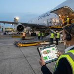 Petugas bandara memantau pergerakan dan beban pesawat kargo menggunakan fitur kontrol muatan AVAGOS pada tablet