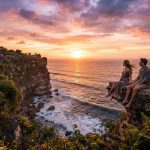Wisatawan menikmati sunset spektakuler di atas tebing laut Bali