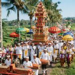 Prosesi upacara kematian di bali dengan gamelan dan payung warna cerah